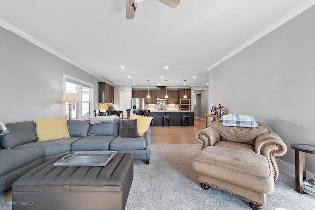 living area featuring crown molding, baseboards, recessed lighting, light wood-style floors, and a ceiling fan