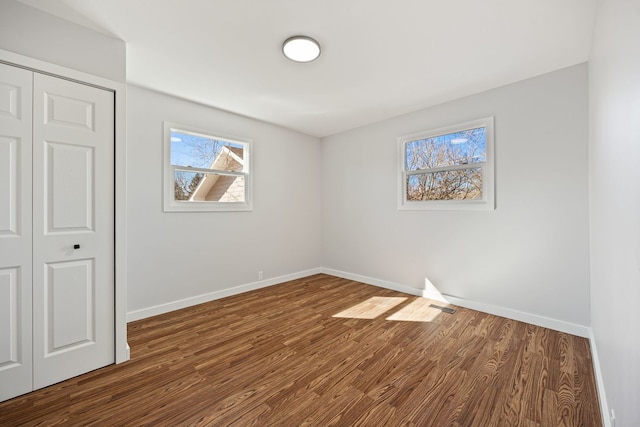 interior space with visible vents, wood finished floors, baseboards, and a closet