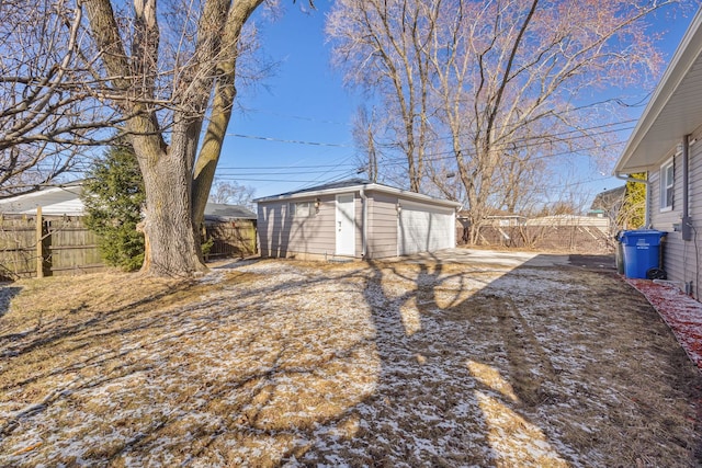 view of yard featuring an outdoor structure, fence, and a detached garage