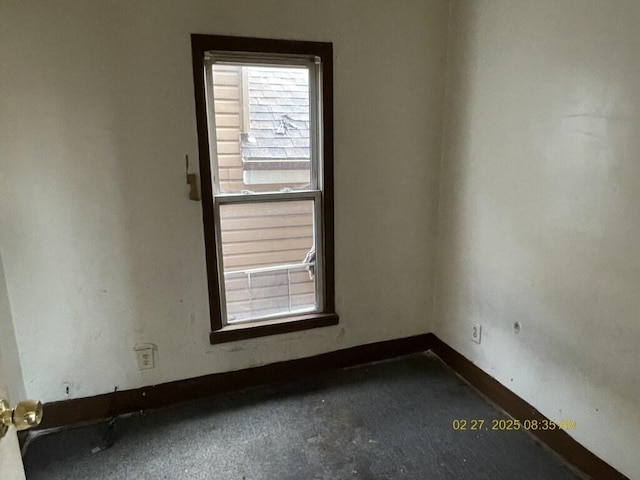 unfurnished room featuring plenty of natural light and baseboards