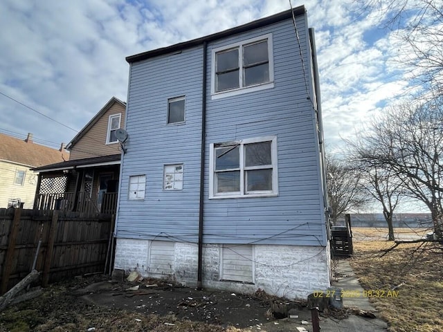 rear view of house featuring fence