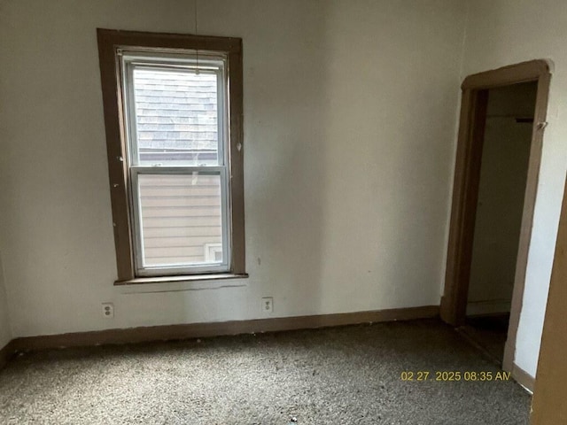 carpeted spare room featuring baseboards