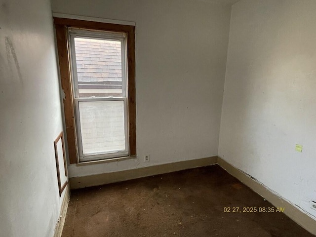 unfurnished room featuring a wealth of natural light and baseboards