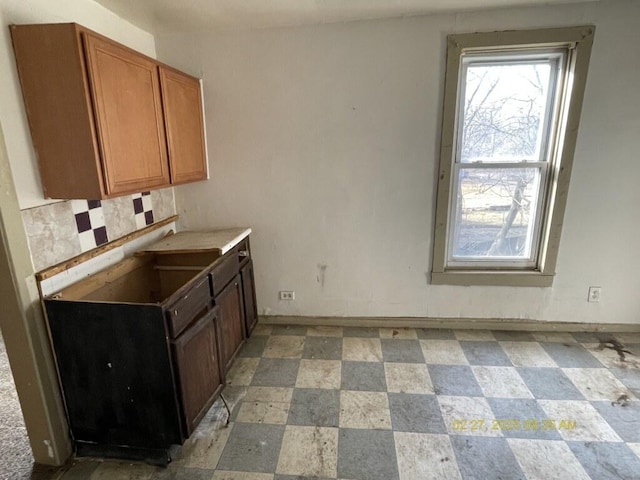 kitchen with plenty of natural light, brown cabinets, and baseboards