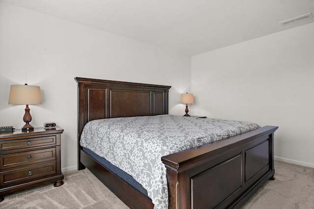 bedroom featuring baseboards, visible vents, and light carpet