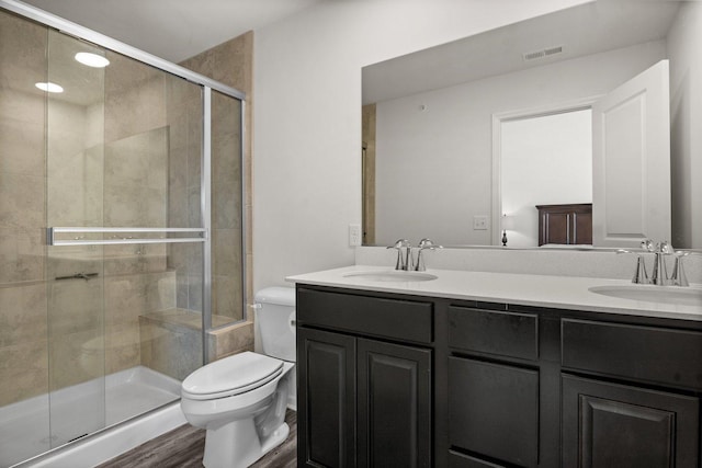 bathroom featuring double vanity, toilet, visible vents, and a sink
