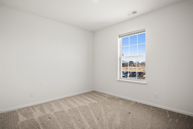 spare room with visible vents, carpet floors, and baseboards