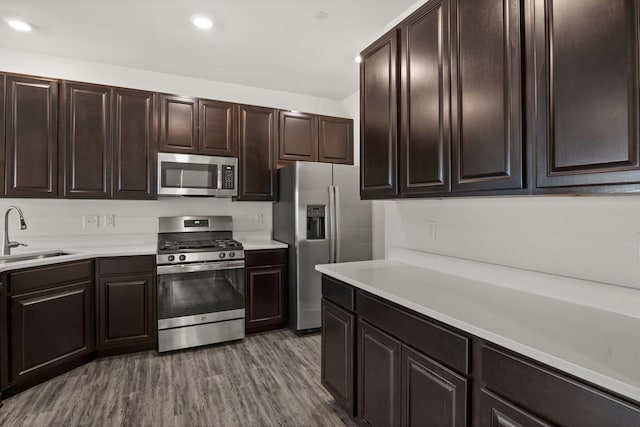 kitchen featuring light countertops, wood finished floors, appliances with stainless steel finishes, and a sink
