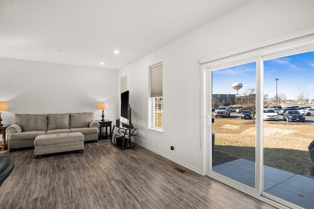living room with visible vents, recessed lighting, baseboards, and wood finished floors