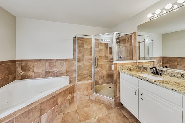 bathroom with a jetted tub, a stall shower, vanity, and tile patterned flooring