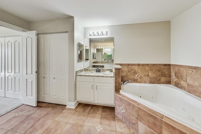 bathroom featuring tile patterned floors, a closet, vanity, and a whirlpool tub