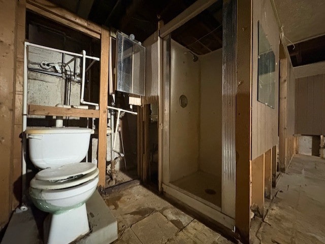 bathroom featuring toilet and a shower stall