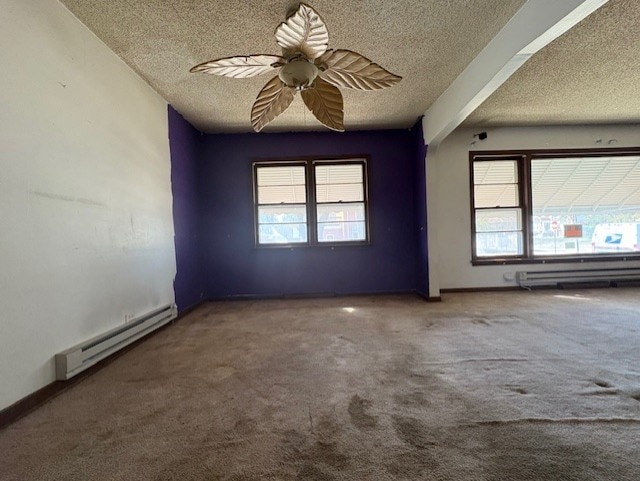 carpeted spare room with a healthy amount of sunlight, a textured ceiling, and a baseboard radiator