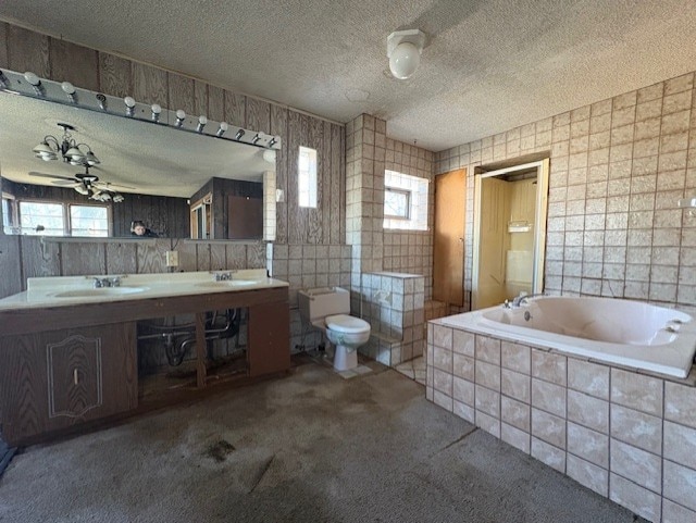 bathroom featuring a sink, a textured ceiling, a wealth of natural light, and toilet