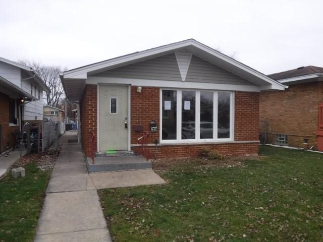 back of property featuring entry steps, a yard, and brick siding