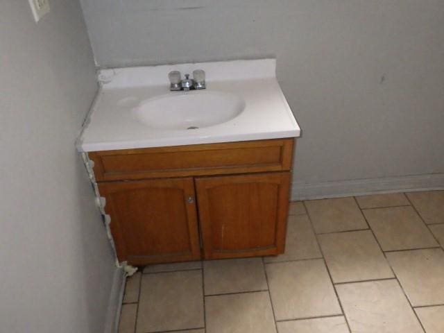 bathroom with baseboards, vanity, and tile patterned flooring