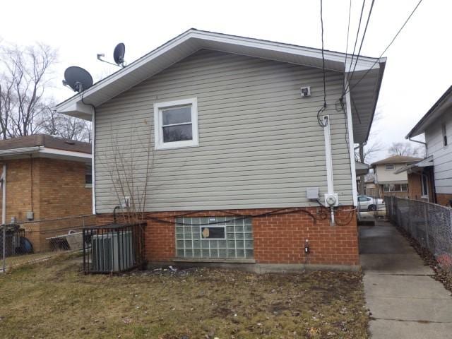 view of home's exterior with brick siding and fence