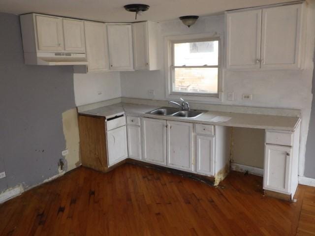 kitchen with a sink, white cabinets, dark wood-style flooring, and light countertops