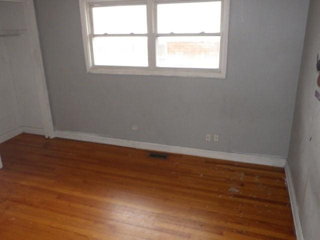 empty room with light wood-style floors, baseboards, and visible vents