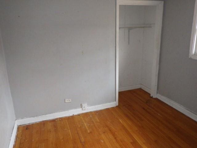 unfurnished bedroom featuring a closet, light wood-style flooring, and baseboards