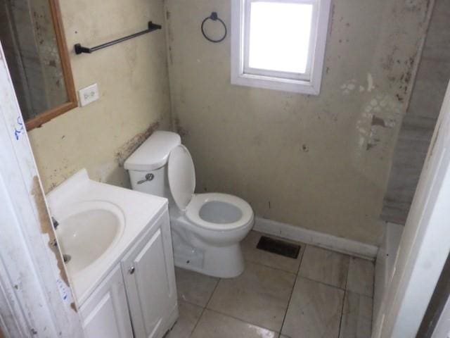 bathroom featuring visible vents, baseboards, toilet, tile patterned floors, and vanity