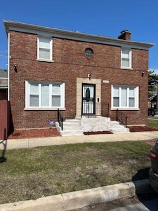 view of front of property featuring brick siding and a chimney