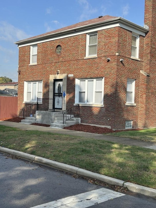 view of front of home with brick siding and a front lawn