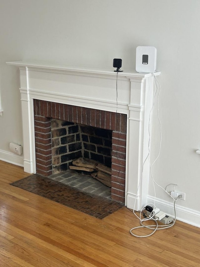 interior details with a fireplace, baseboards, and wood finished floors