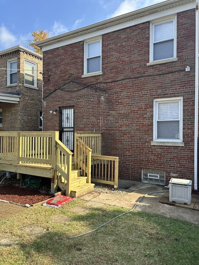 rear view of house with a wooden deck and brick siding