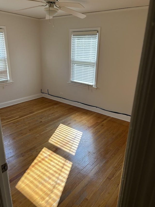unfurnished room with baseboards, ceiling fan, and wood finished floors