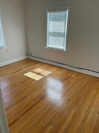 unfurnished room featuring baseboards and wood finished floors