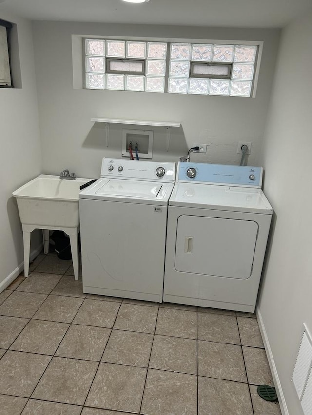 washroom with baseboards, laundry area, tile patterned floors, and washer and clothes dryer
