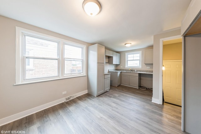 kitchen with visible vents, baseboards, light countertops, light wood-type flooring, and gray cabinets