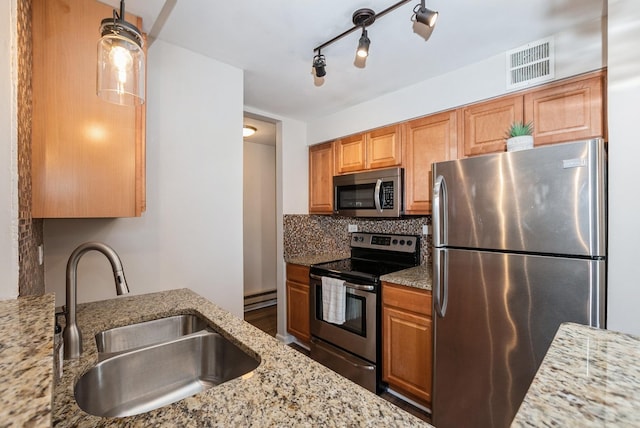 kitchen with visible vents, baseboard heating, decorative backsplash, stainless steel appliances, and a sink