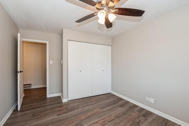 unfurnished bedroom featuring baseboards, dark wood-style floors, a closet, and a baseboard radiator