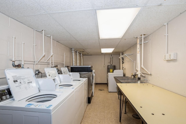 clothes washing area featuring separate washer and dryer, light floors, and electric water heater