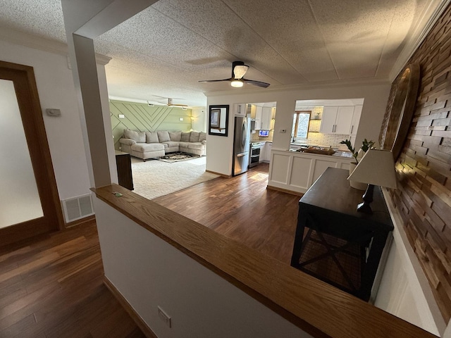 corridor featuring dark wood-style floors, visible vents, and baseboards