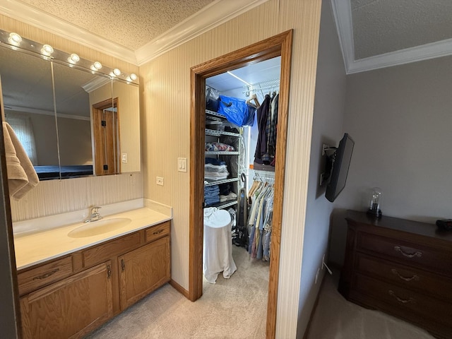 bathroom featuring a textured ceiling, a spacious closet, and ornamental molding