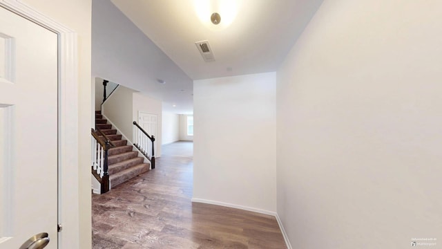 hall featuring visible vents, stairway, baseboards, and wood finished floors