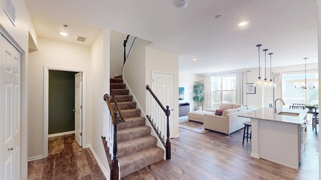 stairway featuring recessed lighting, wood finished floors, and visible vents