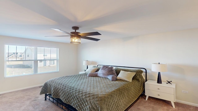 carpeted bedroom with baseboards and a ceiling fan