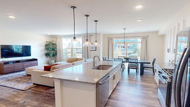 kitchen with a sink, dark wood-style floors, appliances with stainless steel finishes, and white cabinets