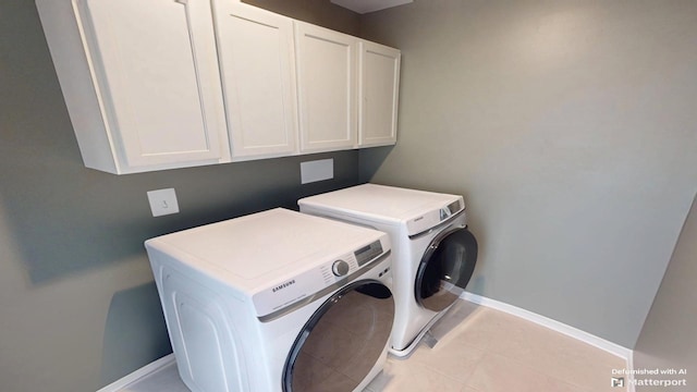 clothes washing area featuring cabinet space, baseboards, and washer and clothes dryer