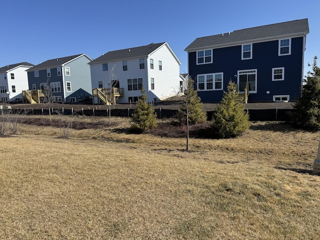 back of property featuring a residential view, a yard, and fence