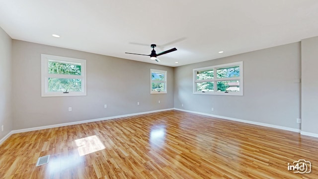 spare room with visible vents, light wood-style floors, baseboards, and ceiling fan