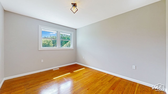 spare room with visible vents, baseboards, and light wood-style floors