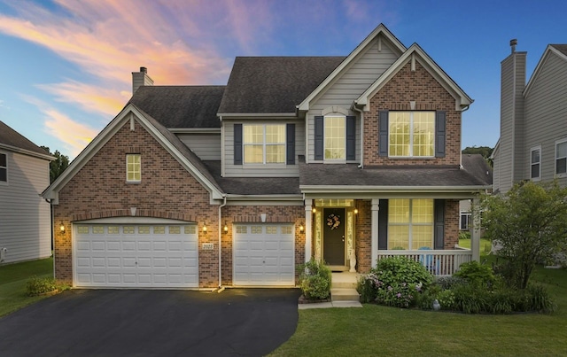 view of front of house with a porch, an attached garage, aphalt driveway, a lawn, and brick siding