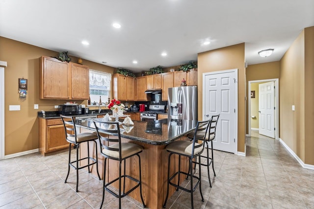 kitchen with a center island, a breakfast bar area, stainless steel appliances, and a sink