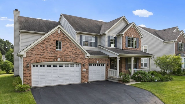 view of front of house featuring a front lawn, driveway, covered porch, brick siding, and a chimney