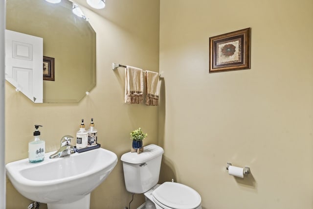 half bathroom featuring a sink and toilet